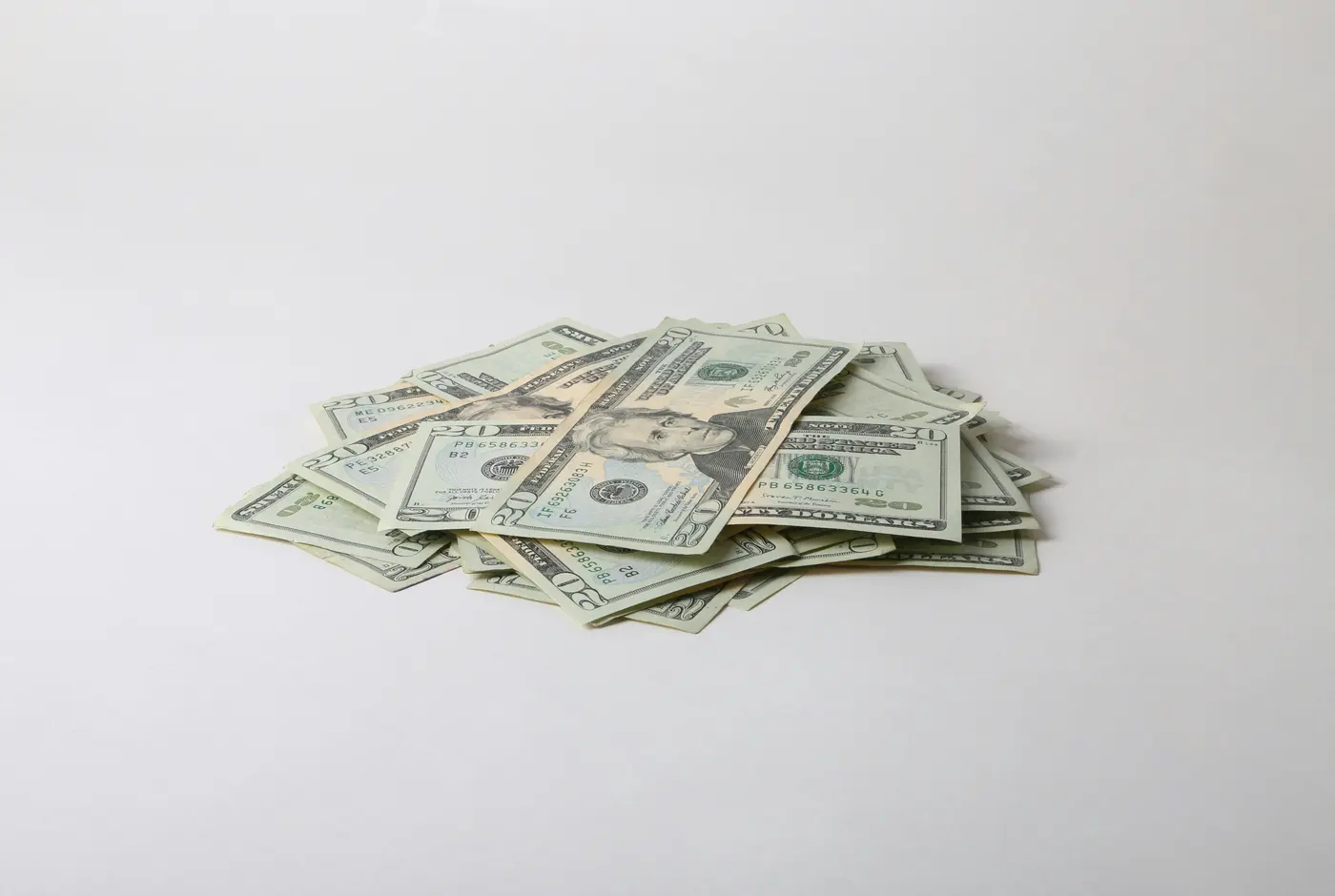 Pile of U.S. twenty-dollar bills on a white table