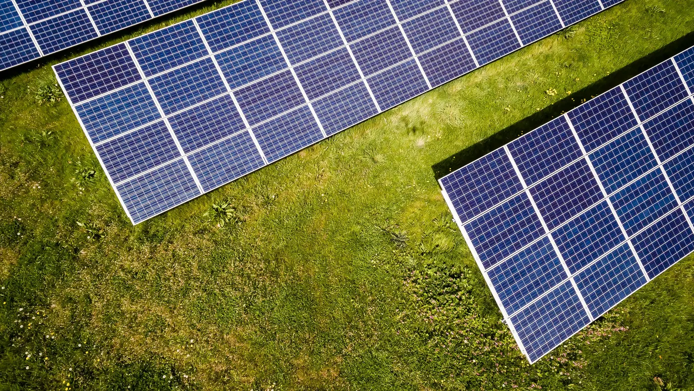 Aerial view of solar panels on green grass