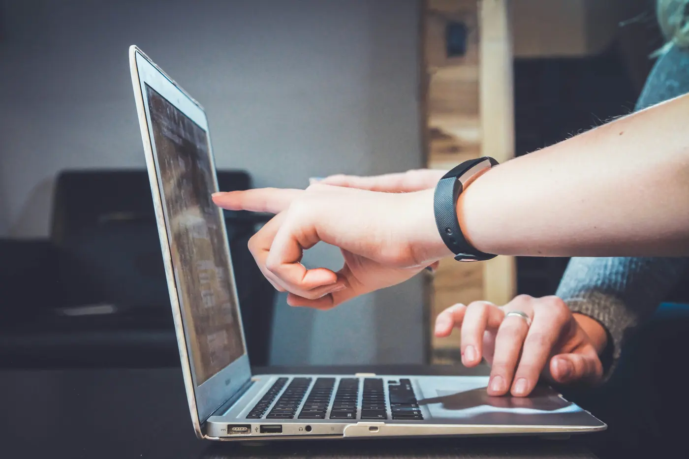 Two people reviewing an application on a laptop screen